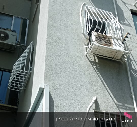 סורגים עם בטן וסורגים ישרים ממתכת לבנה על חלונות בניין